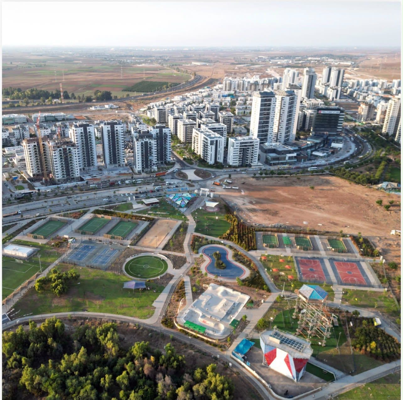 Aerial photograph of Carmei Gat: the sports complex with the occupied neighbourhood and new towers around it