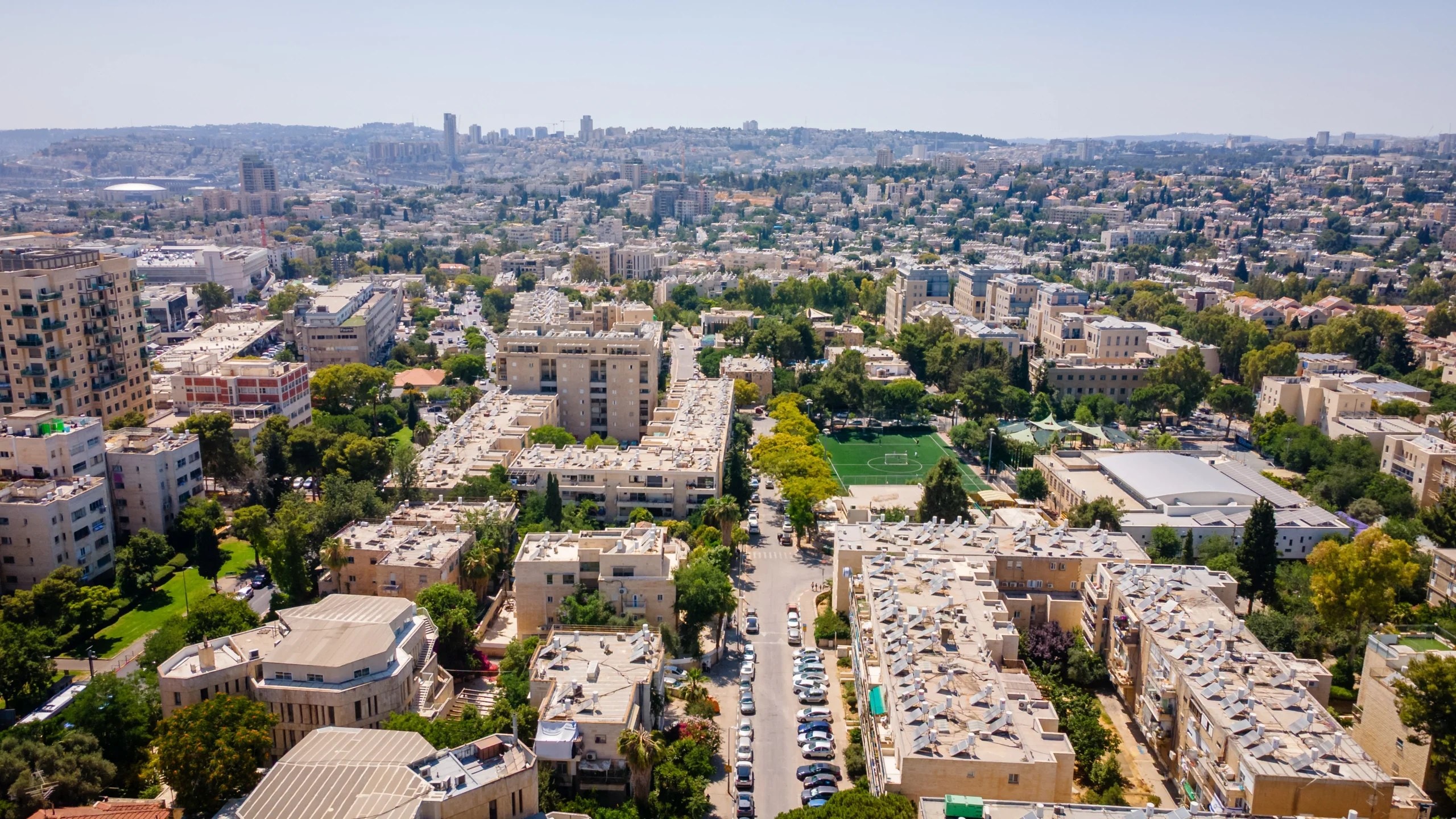 Baka from the air: low stone apartment blocks and gardens, with south Jerusalem stretching to the horizon