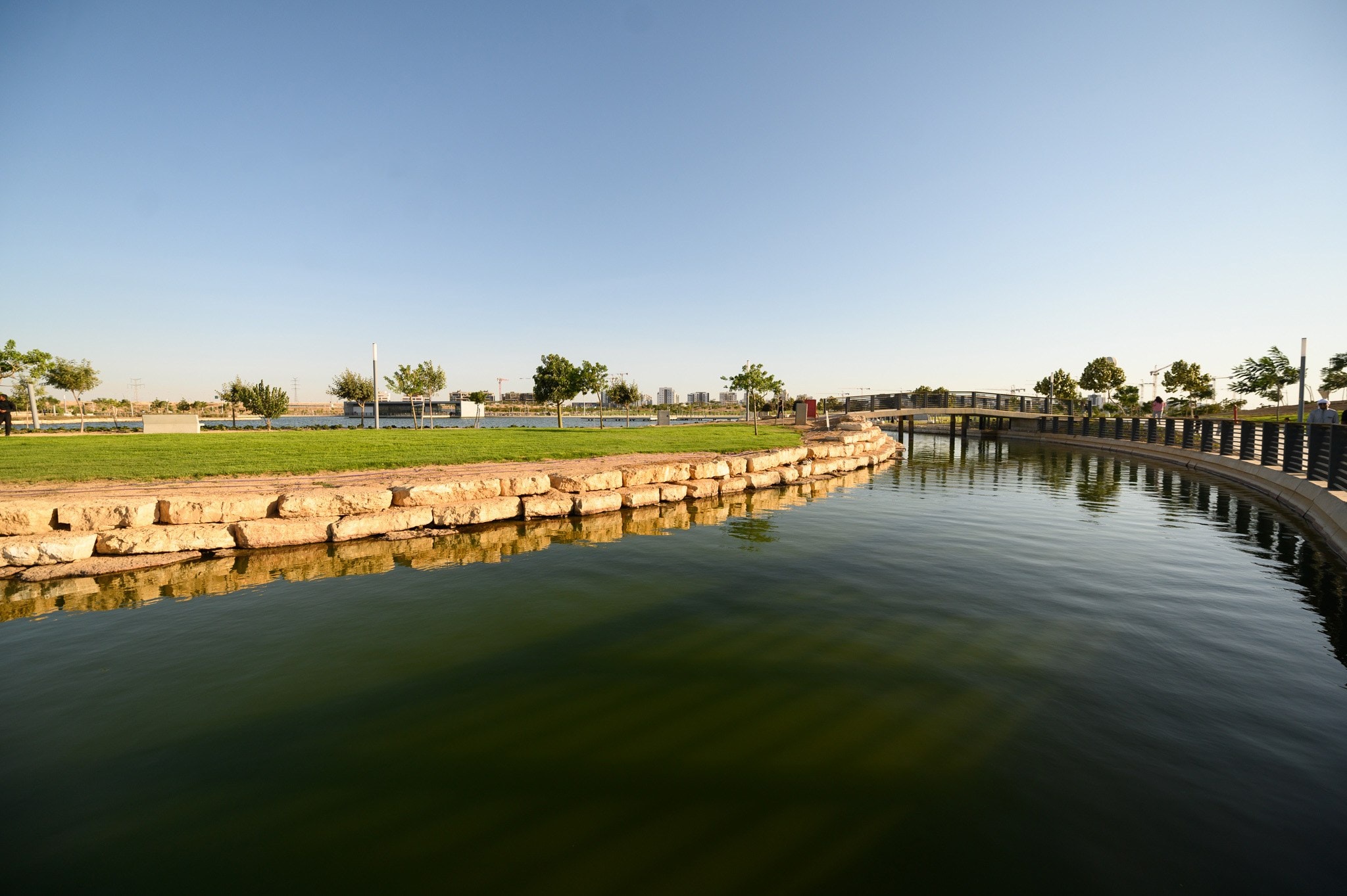 Be'er Sheva River Park: the lake edged with stone and lawns under a clear sky